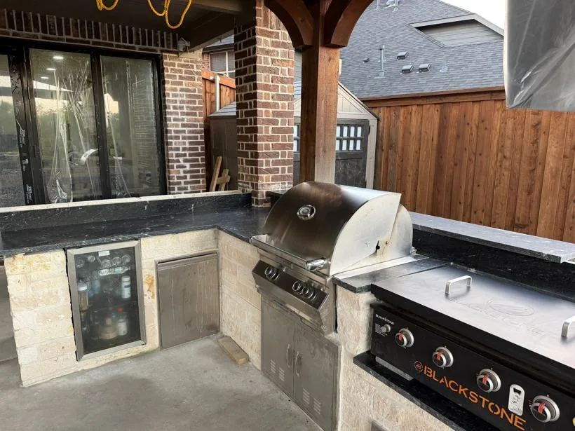 Stone outdoor kitchen with built-in grill
