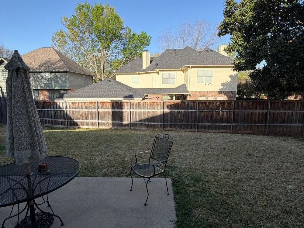 Bare concrete slab and open backyard before construction